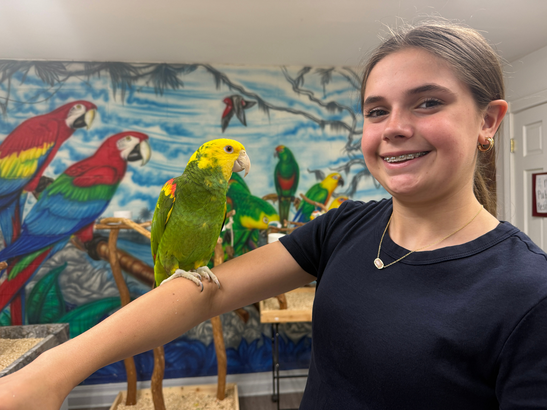 Addyson holding a yellow-headed parrot